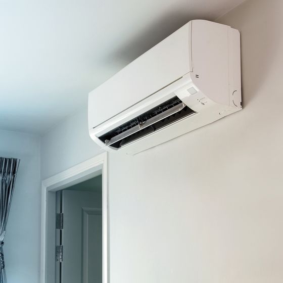 A white high-wall heat pump mounted above a doorway