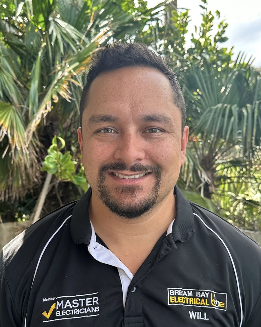 Will Campbell, director of Bream Bay Electrical, in a black company polo shirt, photographed outside